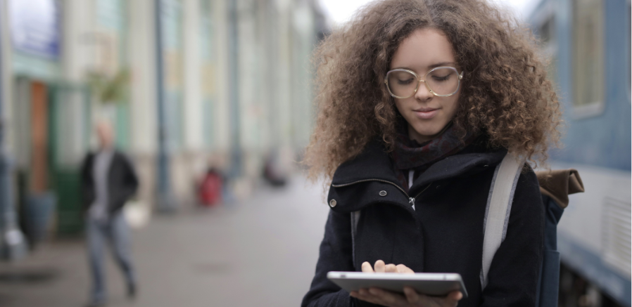 5 Great reasons to use a digital planner - cool woman walking outside reading an ipad